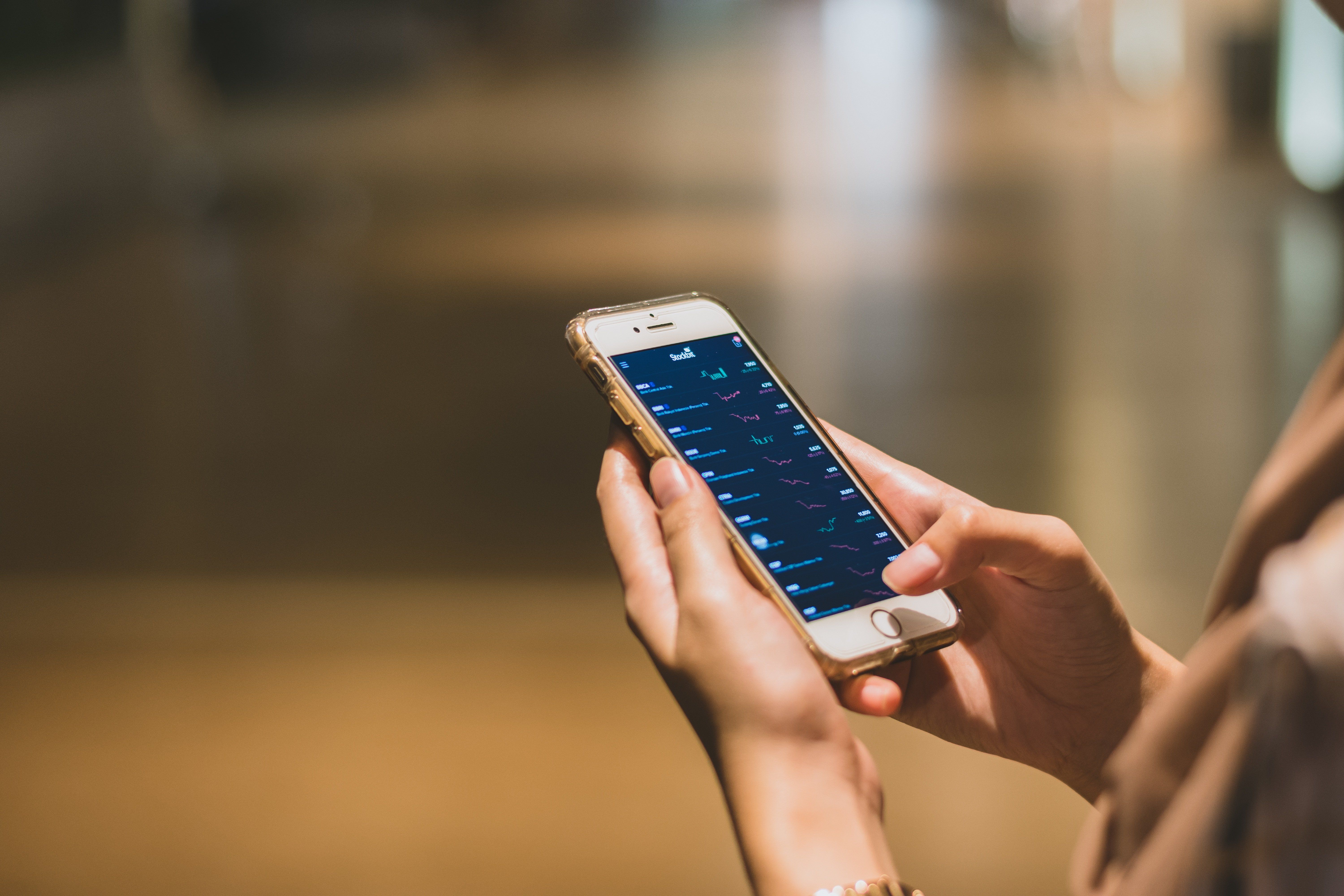 Person hält Smartphone mit Finance-App — kontaktloses Bezahlen ohne separates Terminal